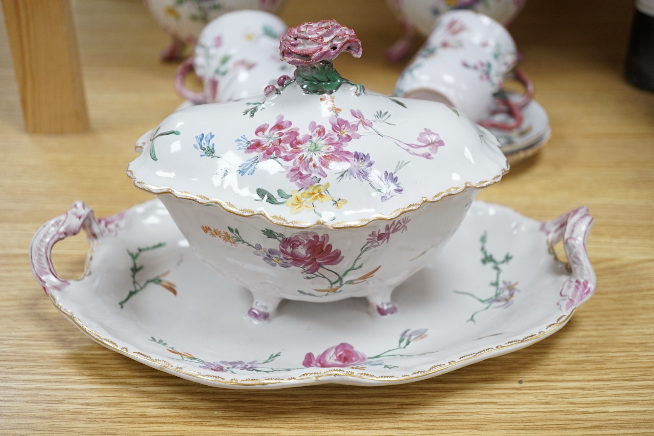 A group of of French faience pottery including a pair of pot pourri vases and covers, a tureen with integral stand, cover, ladle and four coffee cups and saucers